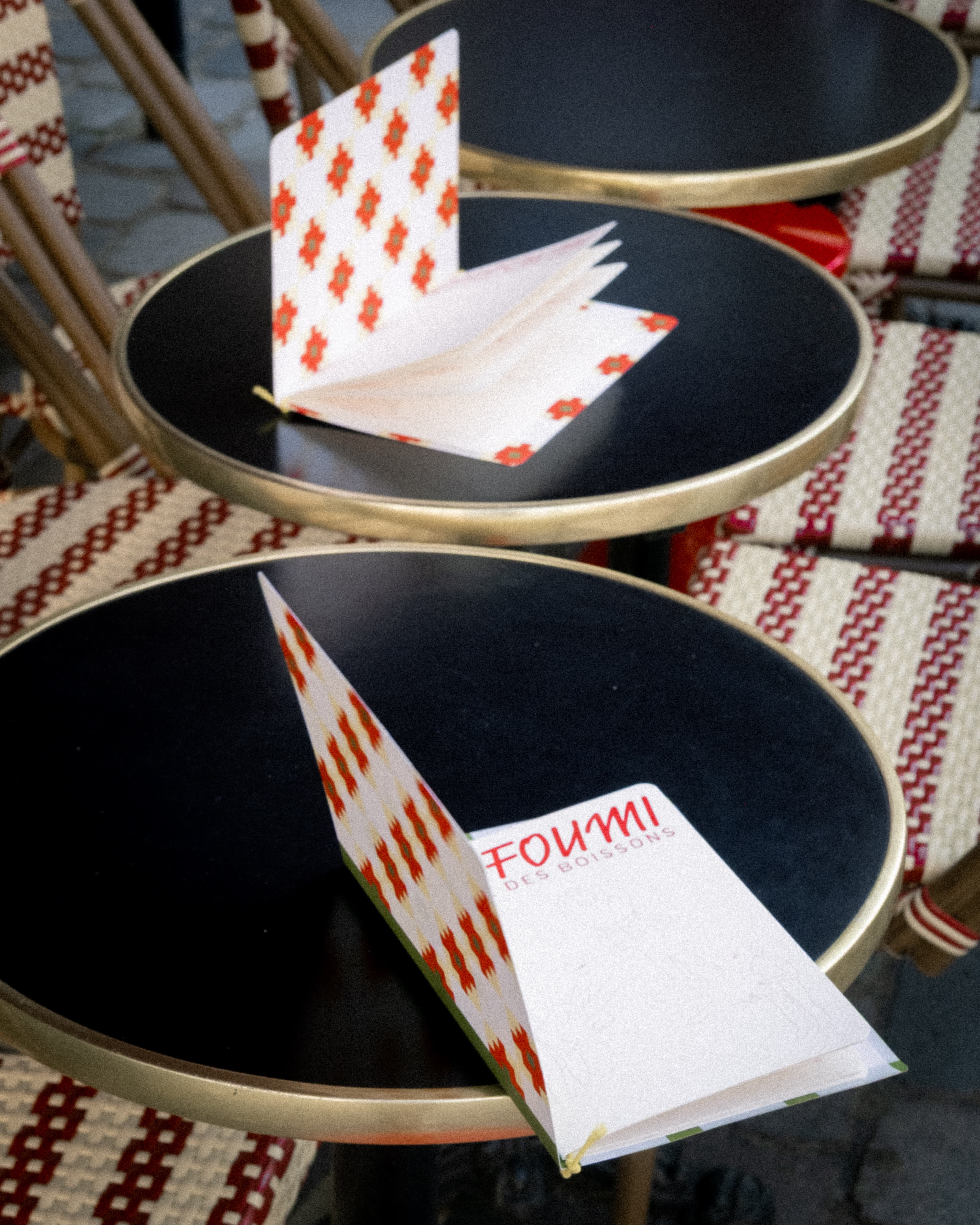 Les cartes des boissons ouvertes sur les guéridons de la terrasse